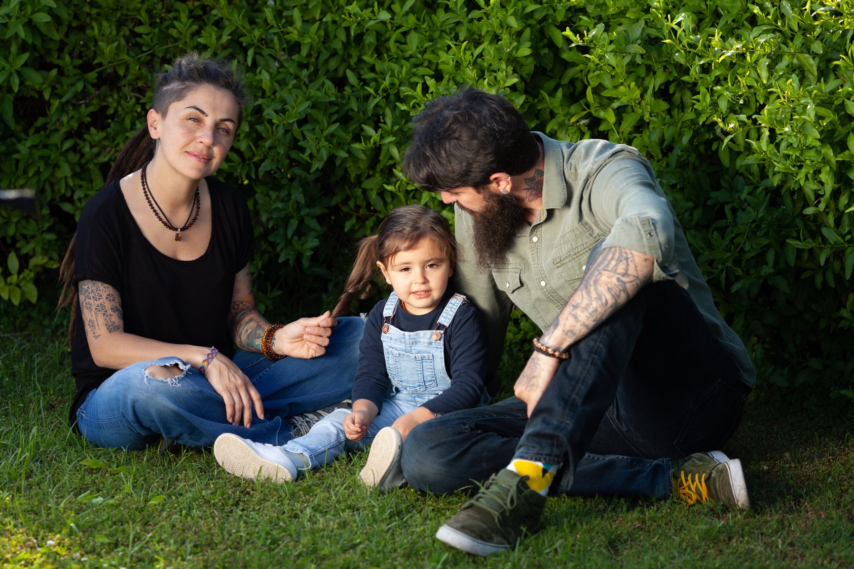 Happy parents with children sitting on the graass